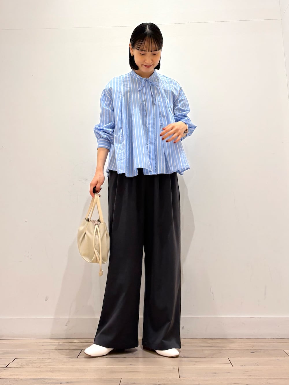 ブルー系のシャツ/ブラウス、グレー系のその他パンツ、ホワイト系のショルダーバッグを着用したレディースの春コーディネートの2枚目の写真