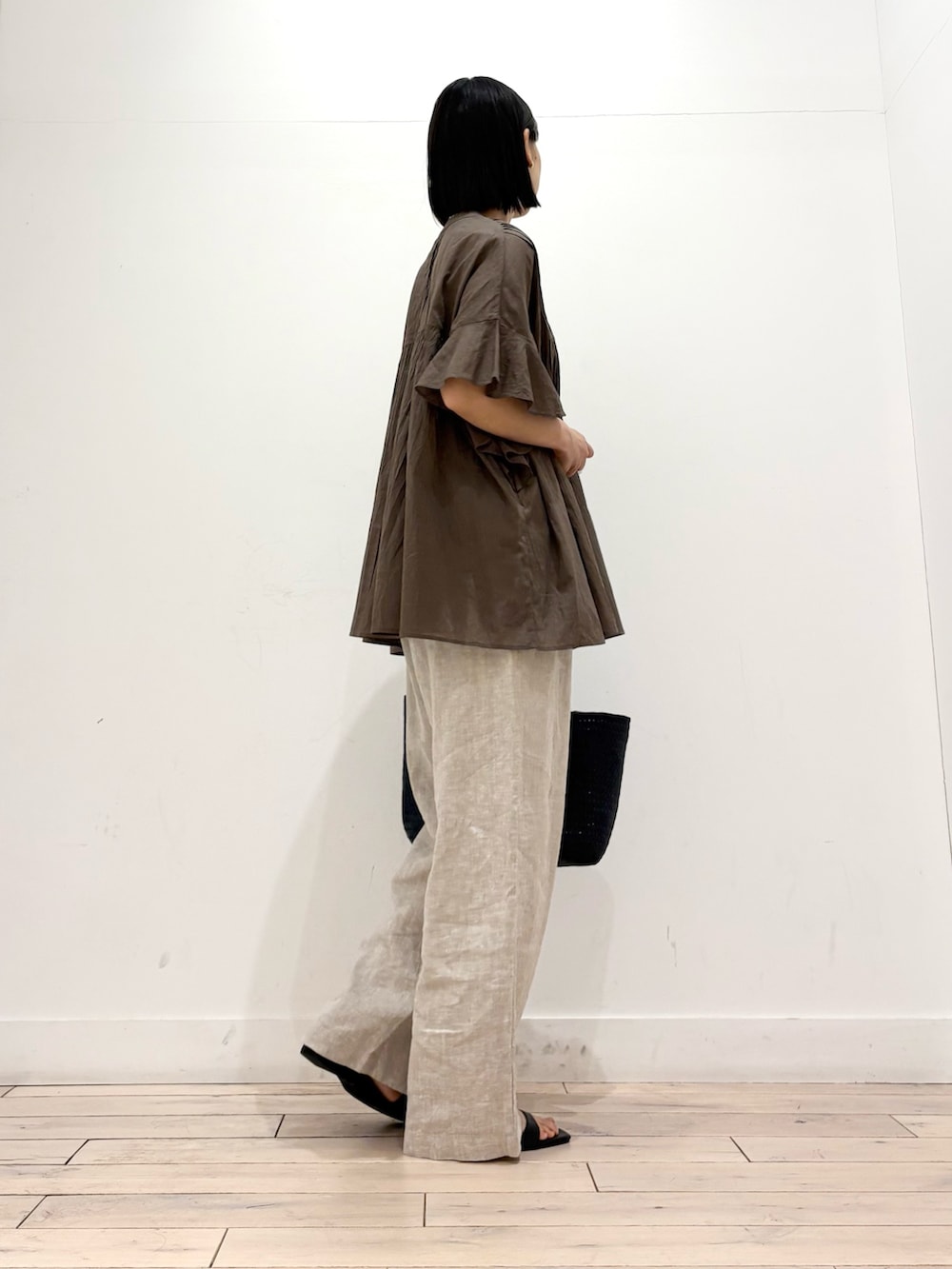 ブルー系のトートバッグ、ベージュ系のその他パンツ、ブラック系のサンダルを着用したレディースの春コーディネートの4枚目の写真