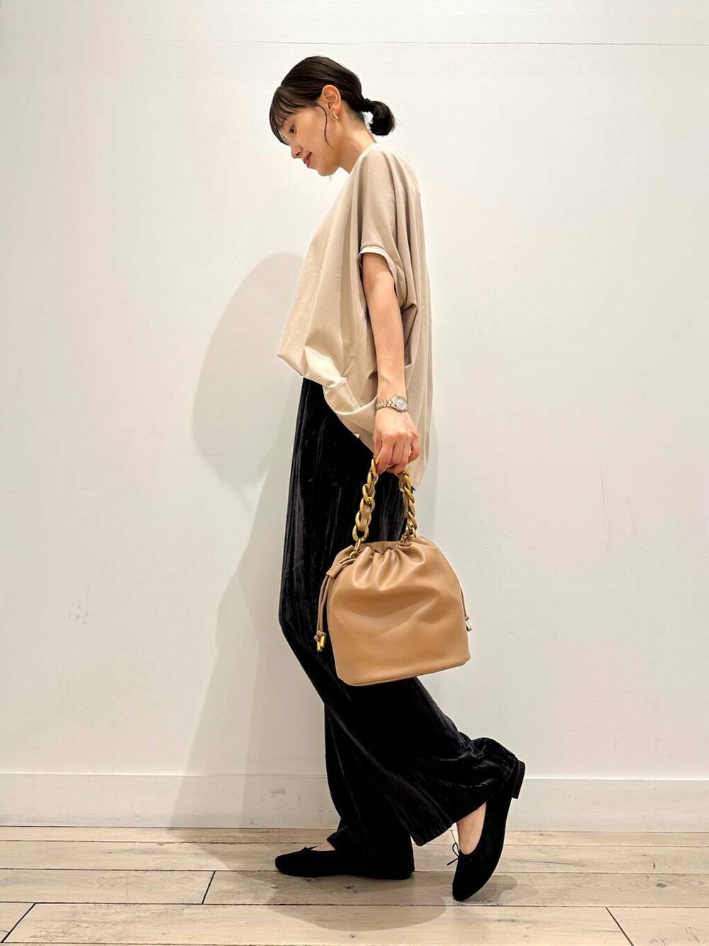 ブラウン系のショルダーバッグ、ブラック系のバレエシューズ、ベージュ系のTシャツ/カットソーを着用したレディースの夏コーディネートの2枚目の写真