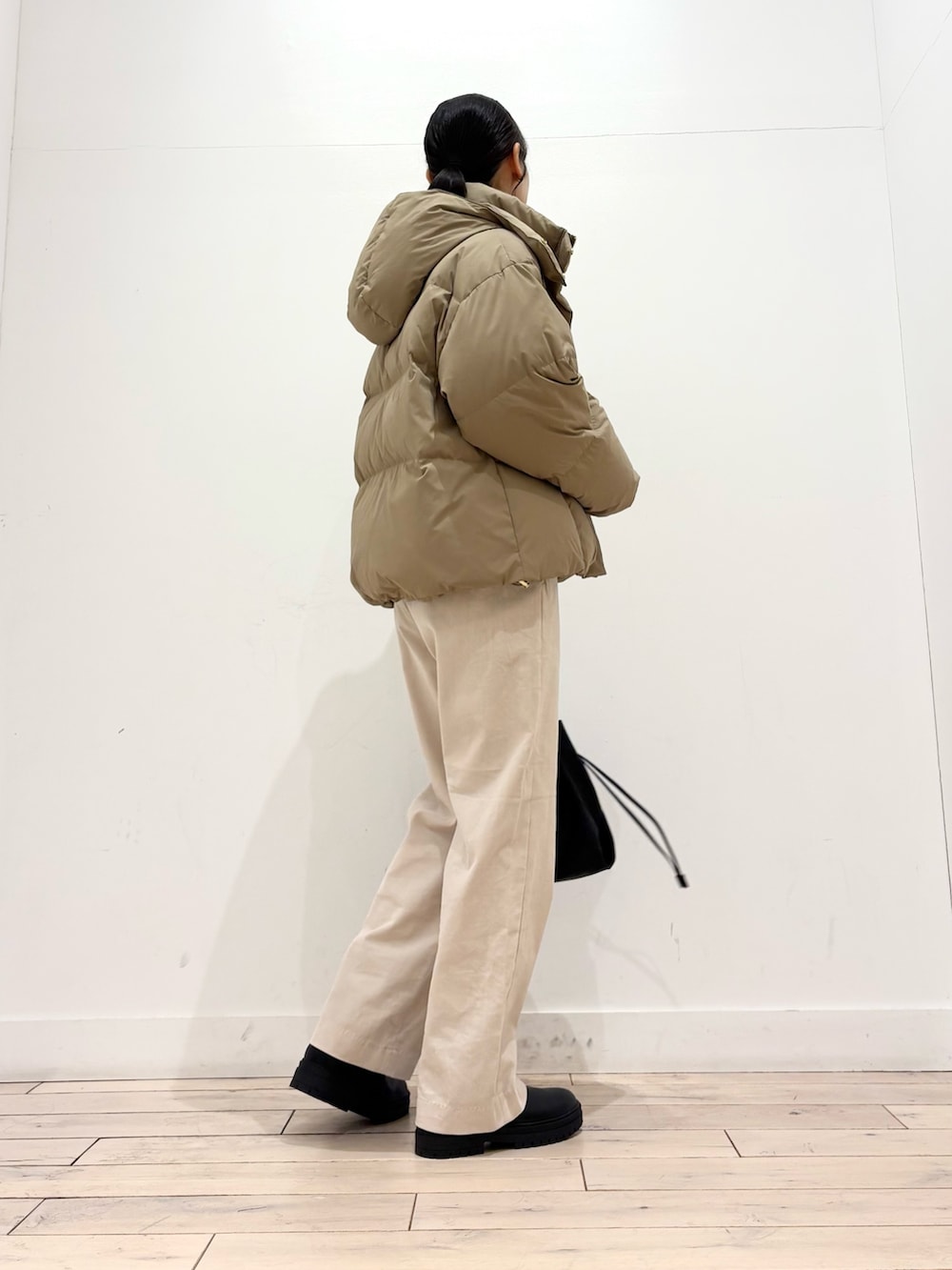 グレー系のニット/セーター、ベージュ系のダウンジャケット/コート、ホワイト系のその他パンツを着用したレディースの冬コーディネートの4枚目の写真