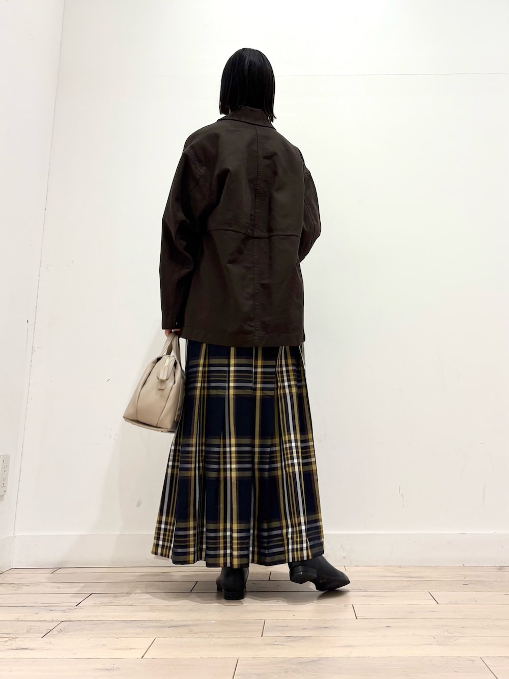 ブラウン系のカバーオール、ホワイト系のTシャツ/カットソー、ブラック系のブーツを着用したレディースの秋コーディネートの3枚目の写真