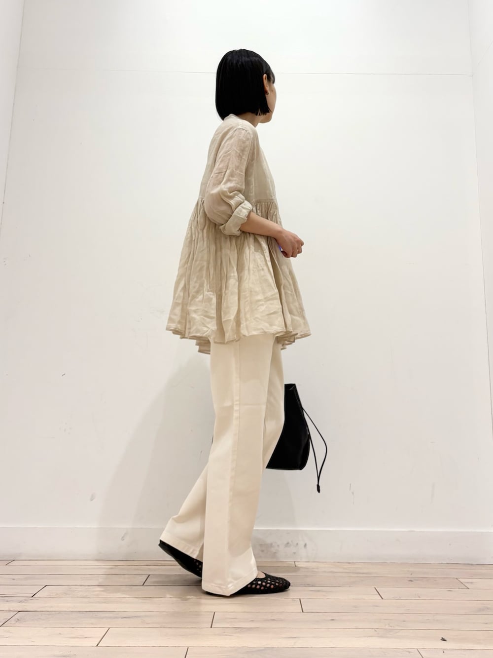 ベージュ系のシャツ/ブラウス、ベージュ系のデニムパンツ、ブラック系のショルダーバッグを着用したレディースの春コーディネートの5枚目の写真