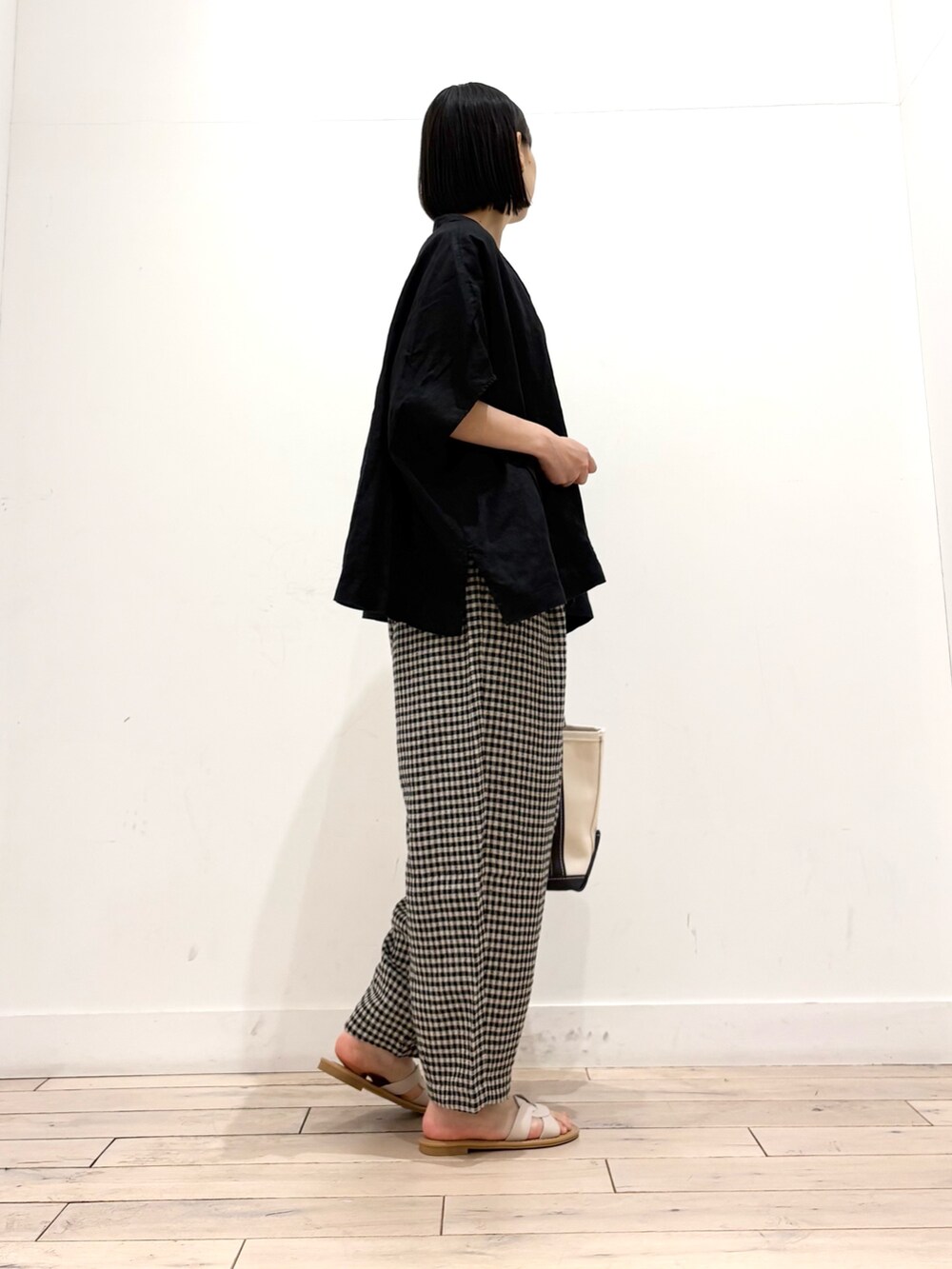 ブラック系のシャツ/ブラウス、ブラック系のその他パンツ、グレー系のトートバッグを着用したレディースの春コーディネートの4枚目の写真