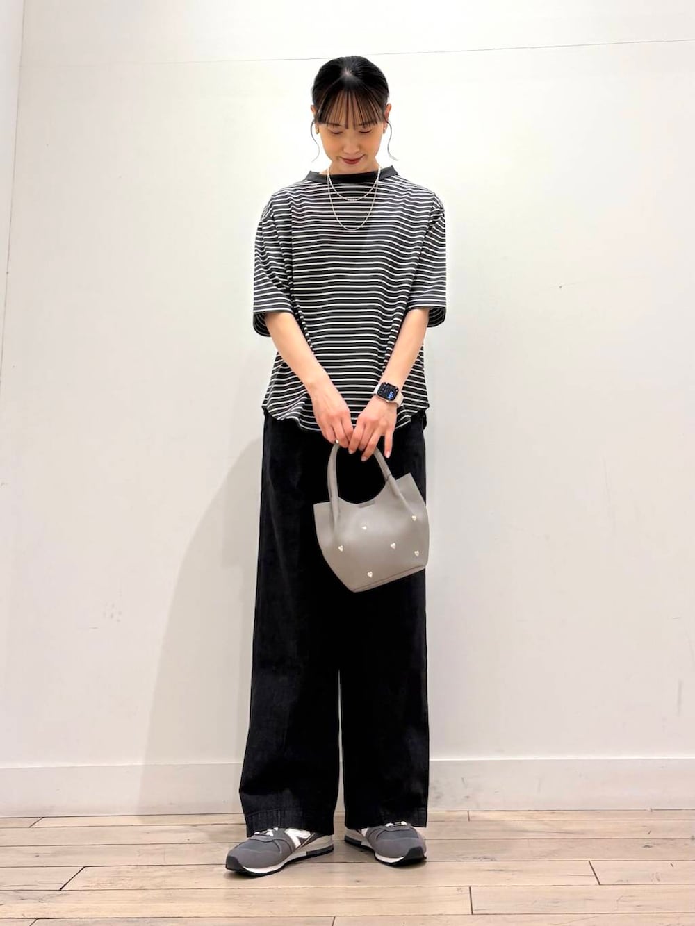 ベージュ系のマウンテンパーカー、ブラック系のデニムパンツ、グレー系のショルダーバッグを着用したレディースの春コーディネートの4枚目の写真