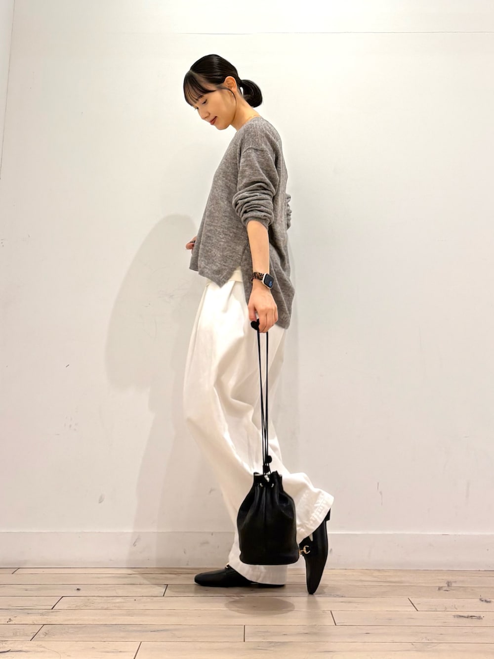 グレー系のニット/セーター、ホワイト系のその他パンツ、ブラック系のショルダーバッグを着用したレディースの秋コーディネートの3枚目の写真