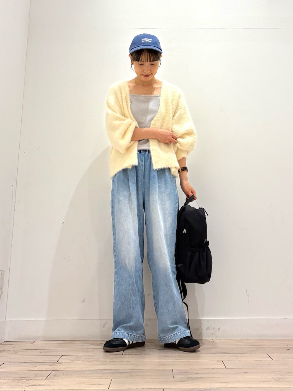 ホワイト系のカーディガン/ボレロ、ブルー系のデニムパンツ、ブラック系のスニーカーを着用したレディースの秋コーディネートの2枚目の写真