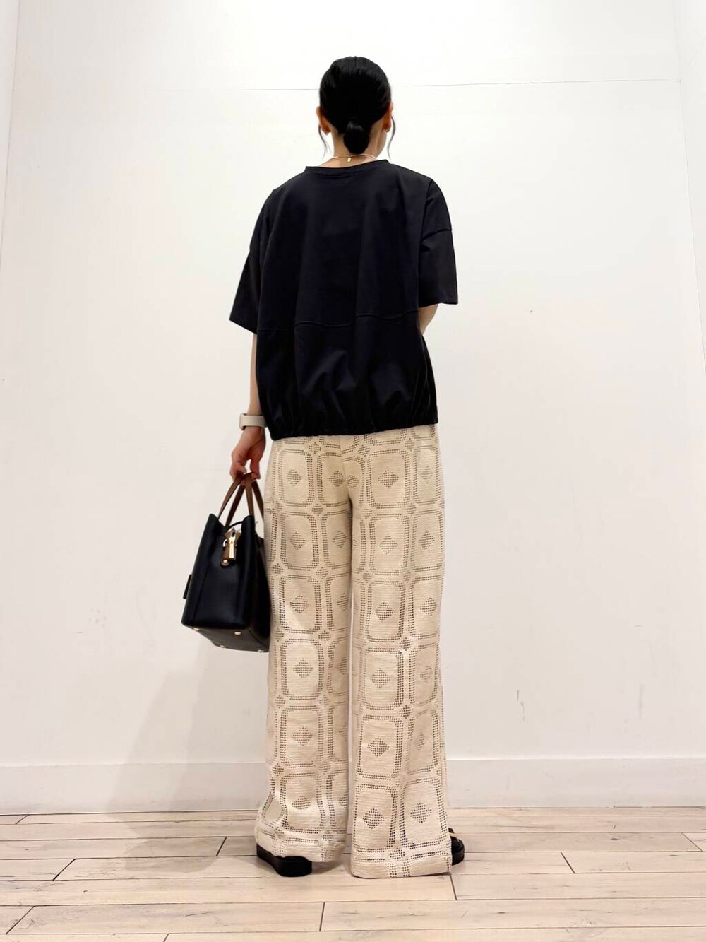 ブラック系のトートバッグ、グレー系のTシャツ/カットソー、ブラック系のサンダルを着用したレディースの夏コーディネートの4枚目の写真