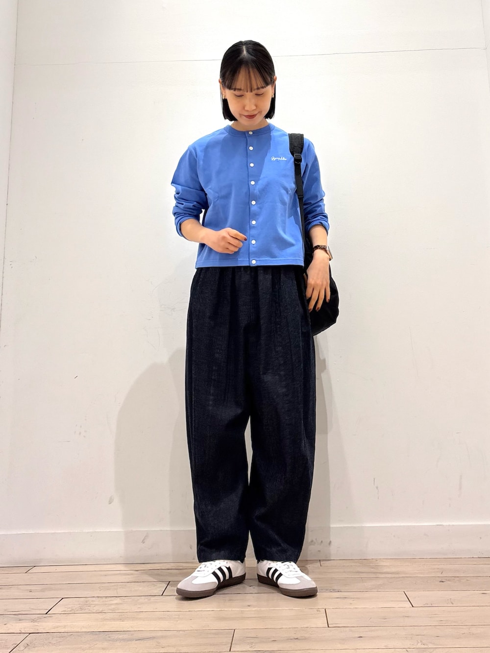 ブルー系のカーディガン/ボレロ、ブルー系のデニムパンツ、ホワイト系のスニーカーを着用したレディースの春コーディネートの2枚目の写真