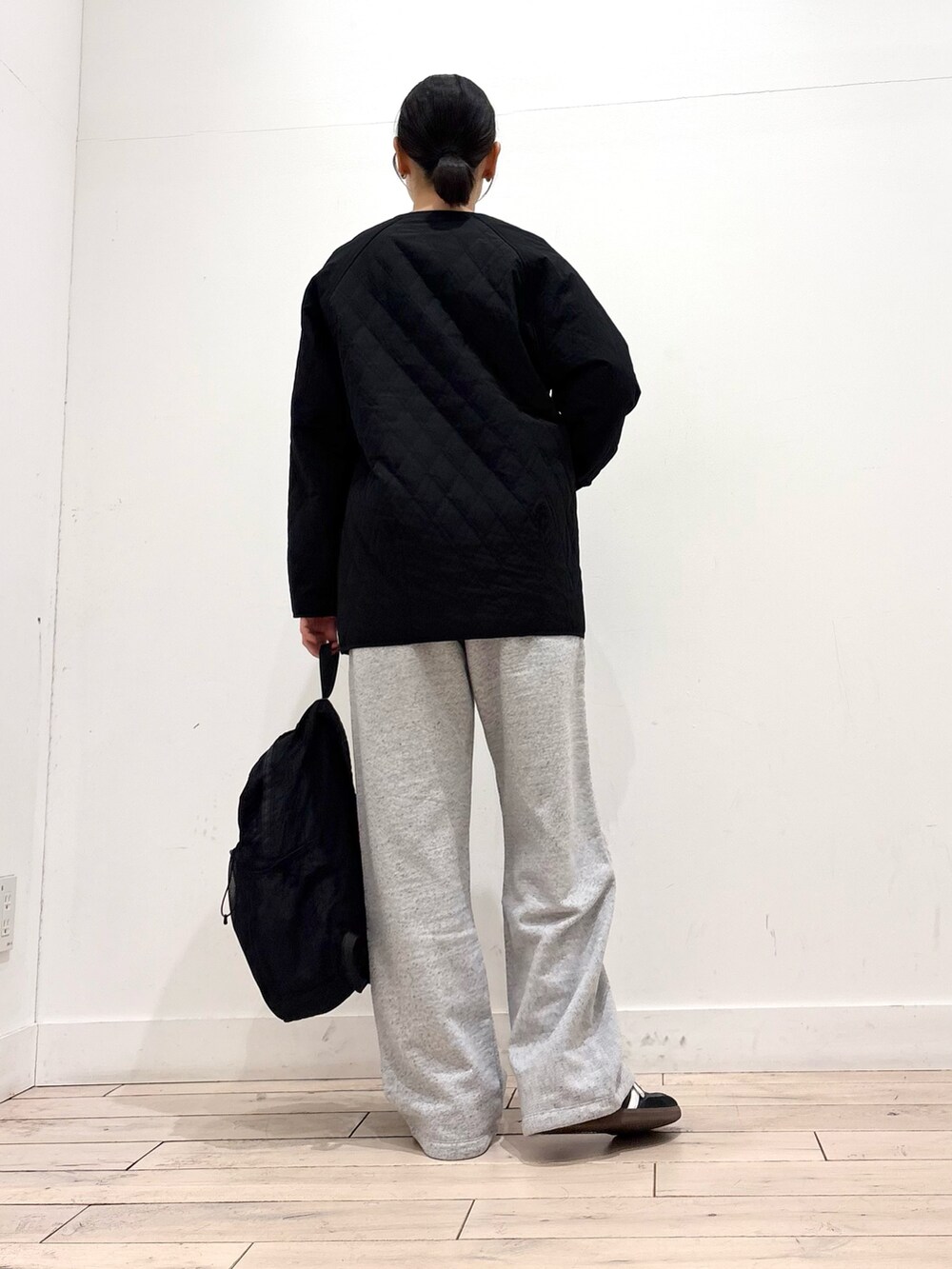 ブルー系のニット/セーター、ブラック系のダウンジャケット/コート、グレー系のその他パンツを着用したレディースの春コーディネートの4枚目の写真