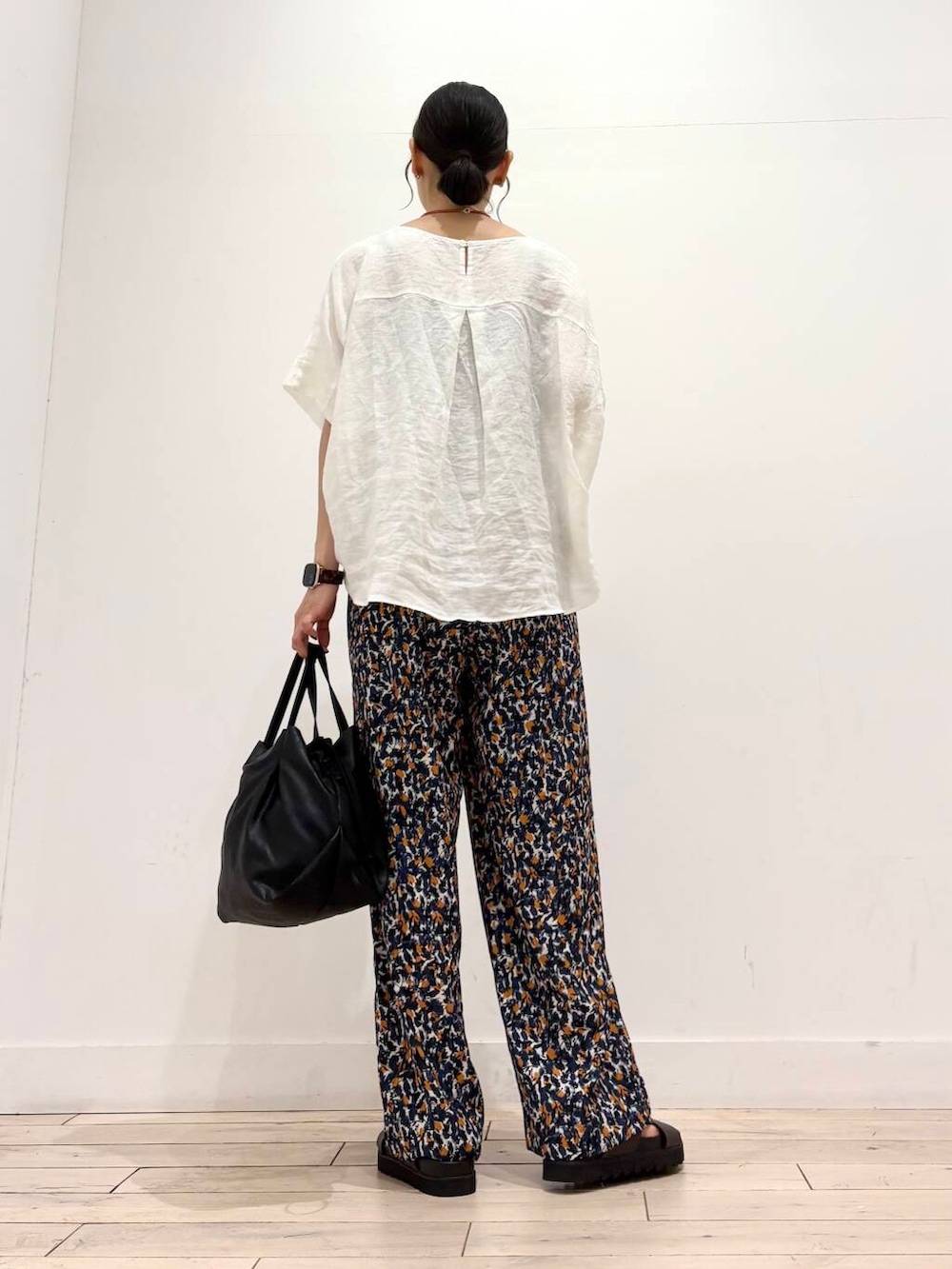 ブラック系のショルダーバッグ、ブラウン系のサンダル、ホワイト系のシャツ/ブラウスを着用したレディースの夏コーディネートの4枚目の写真