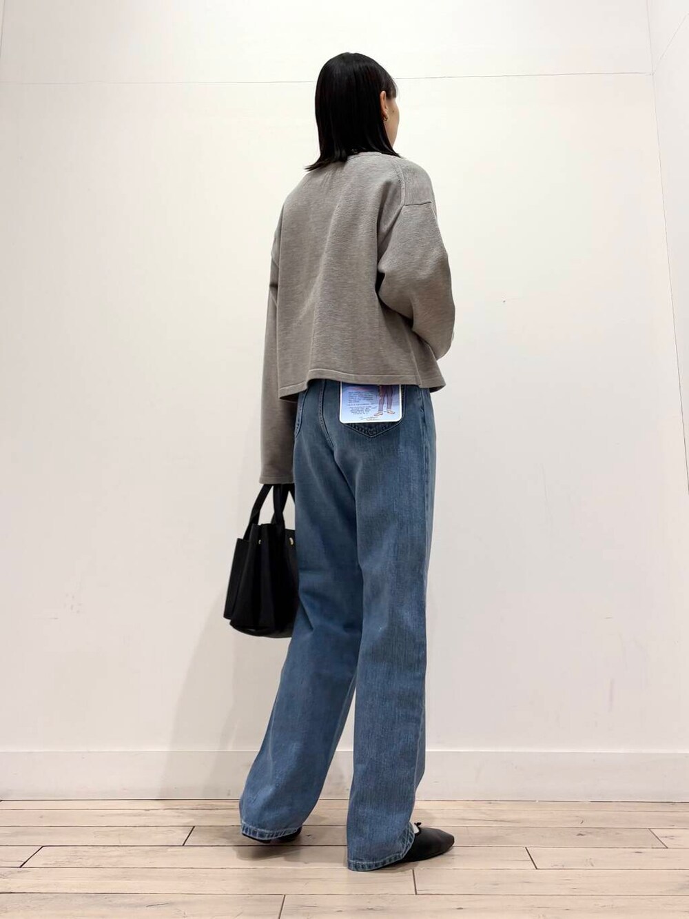 ブラック系のトートバッグ、グレー系のカーディガン/ボレロ、ホワイト系のノーカラージャケットを着用したレディースの冬コーディネートの6枚目の写真