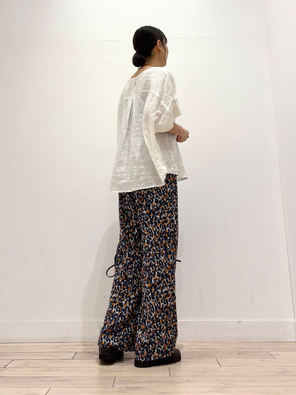 ブラック系のショルダーバッグ、ブラウン系のサンダル、ホワイト系のシャツ/ブラウスを着用したレディースの夏コーディネートの3枚目の写真