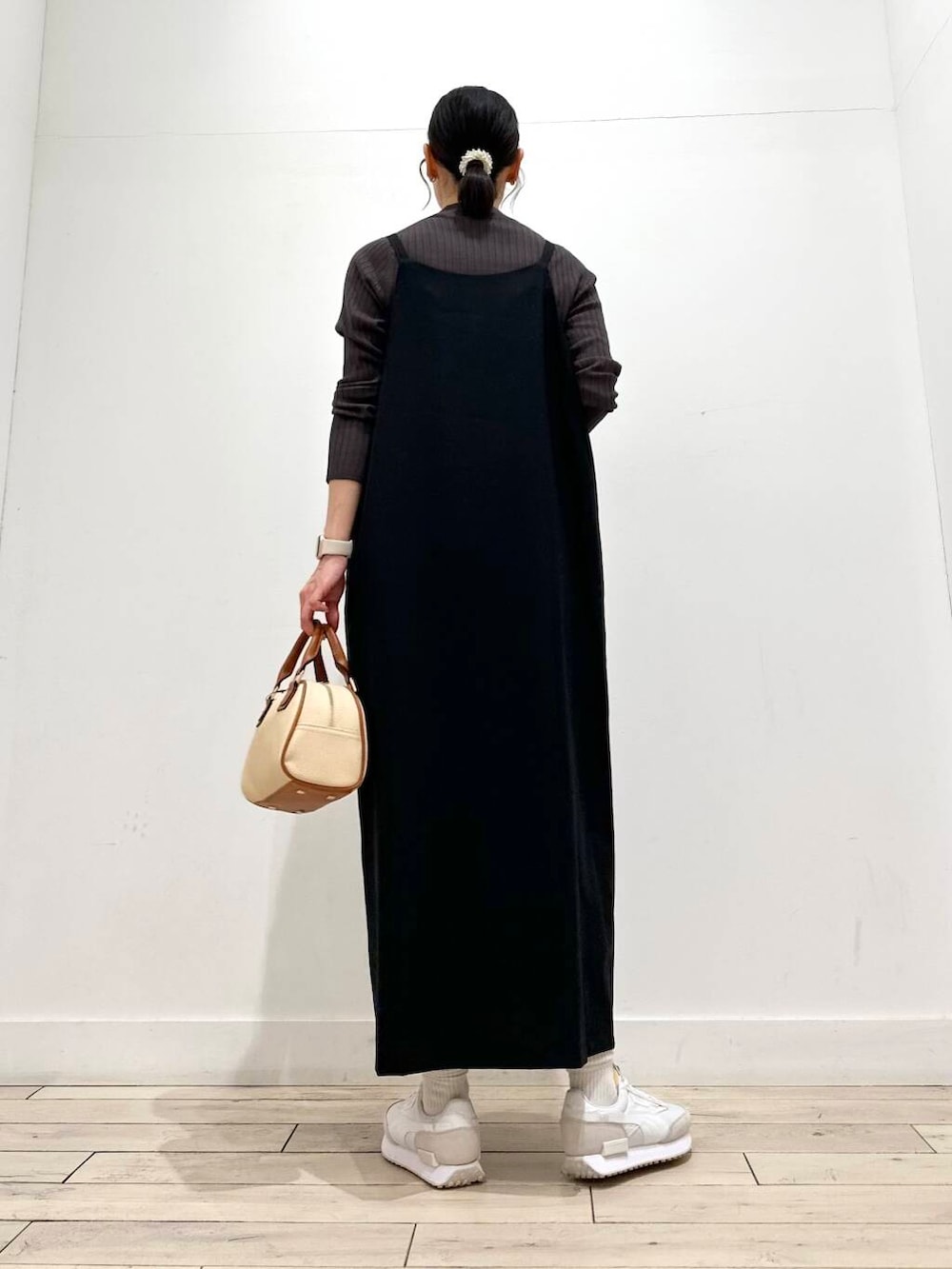 ブラウン系のニット/セーター、ホワイト系のダウンジャケット/コート、イエロー系のボストンバッグを着用したレディースの冬コーディネートの3枚目の写真