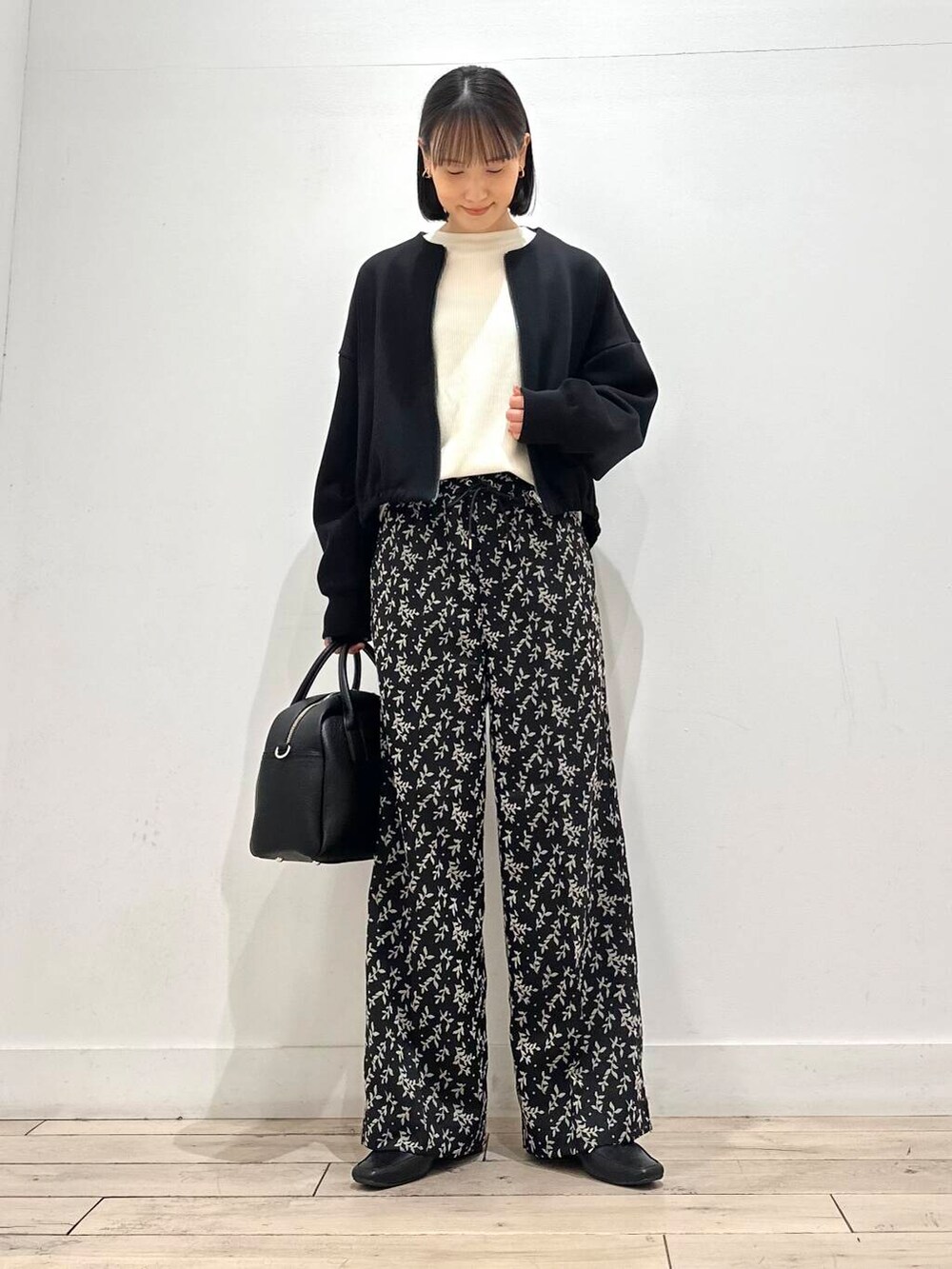 ブラック系のローファー、ベージュ系のTシャツ/カットソー、ブラック系のボストンバッグを着用したレディースの秋コーディネートの2枚目の写真