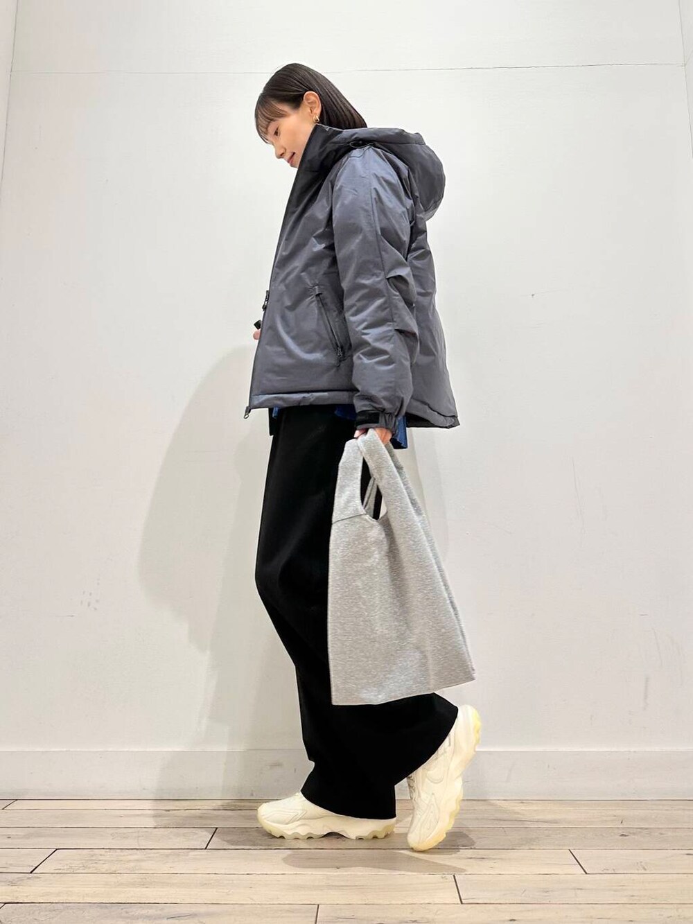 ホワイト系のスニーカー、グリーン系のニット/セーター、シルバー系のトートバッグを着用したレディースの冬コーディネートの2枚目の写真