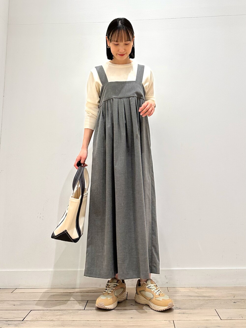 ホワイト系のダウンジャケット/コート、グレー系のワンピースを着用したレディースの春コーディネートの2枚目の写真