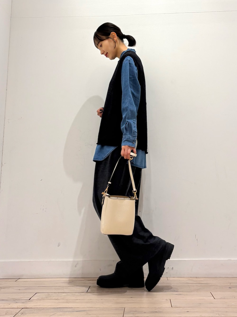 ブラック系のベスト、ブルー系のシャツ/ブラウス、グレー系のその他パンツを着用したレディースの冬コーディネートの2枚目の写真