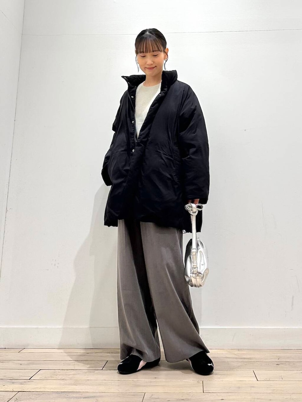 ブラック系のブルゾン、グレー系のその他パンツ、シルバー系のショルダーバッグを着用したレディースの冬コーディネートの4枚目の写真