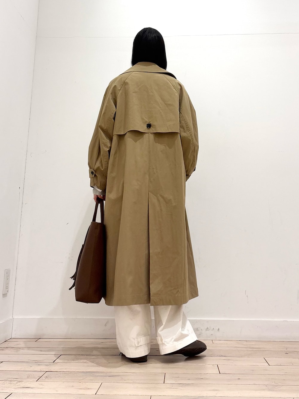 ベージュ系のニット/セーター、ベージュ系のトレンチコート、ブラウン系のトートバッグを着用したレディースの冬コーディネートの3枚目の写真