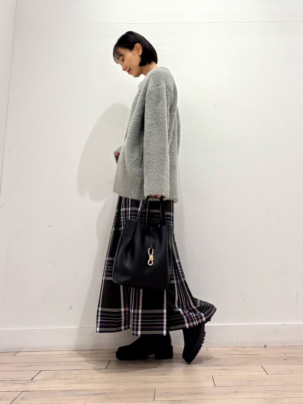 グレー系のカーディガン/ボレロ、ブラック系のトートバッグ、ブラック系のブーツを着用したレディースの秋コーディネートの2枚目の写真