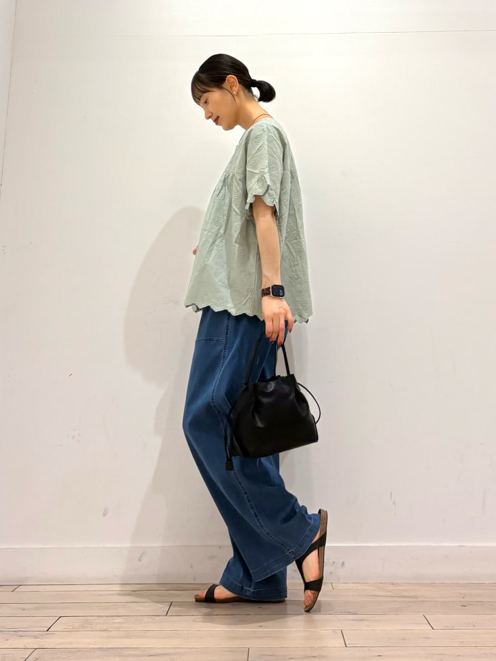 グリーン系のシャツ/ブラウス、ブルー系のデニムパンツ、ブラック系のショルダーバッグを着用したレディースの夏コーディネートの2枚目の写真