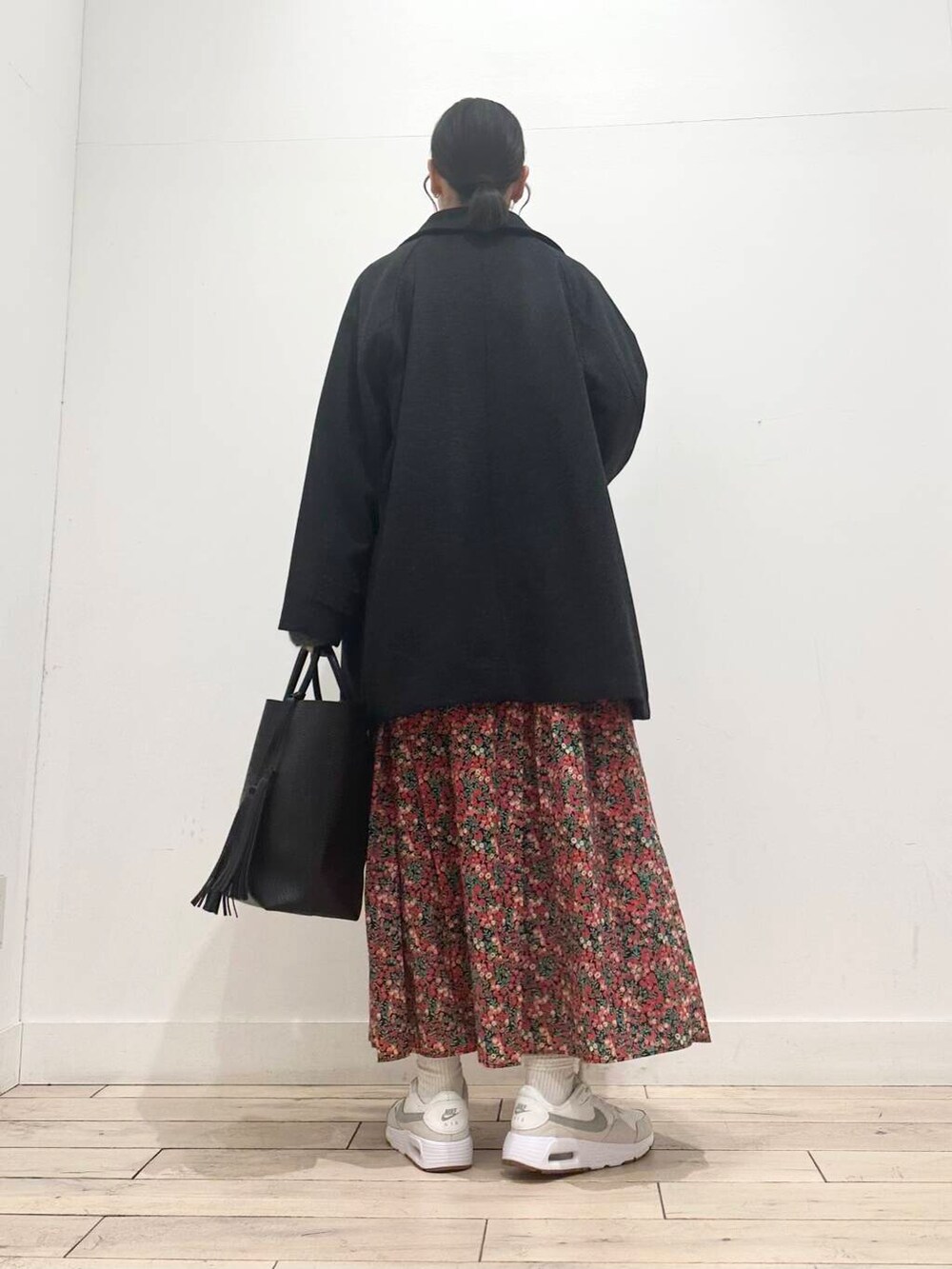 ブラック系のトートバッグ、グレー系のニット/セーター、ホワイト系のスニーカーを着用したレディースの冬コーディネートの6枚目の写真