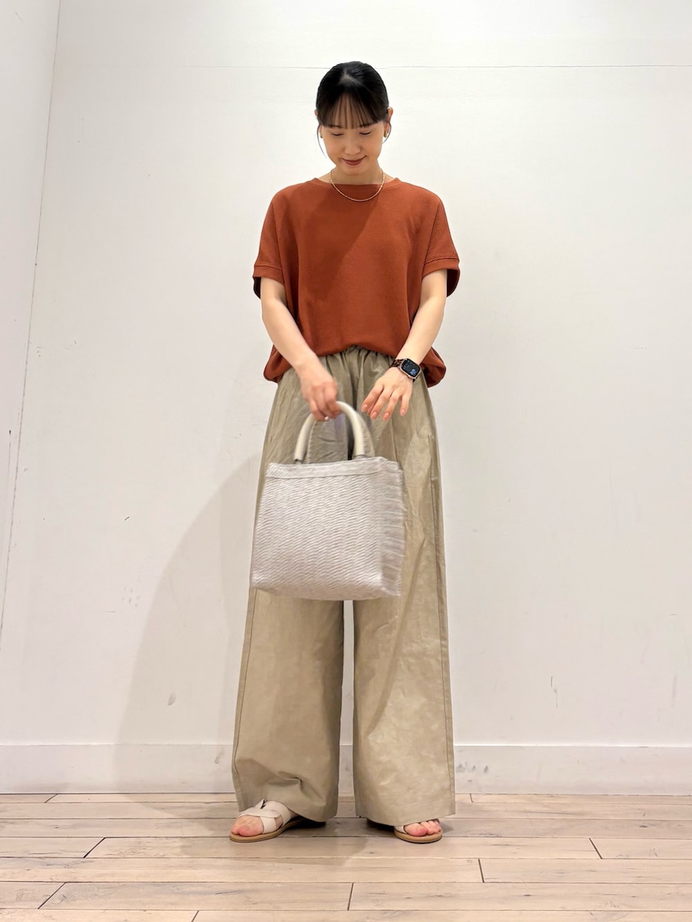 ベージュ系のその他パンツ、グレー系のハンドバッグ、ホワイト系のサンダルを着用したレディースの夏コーディネートの2枚目の写真