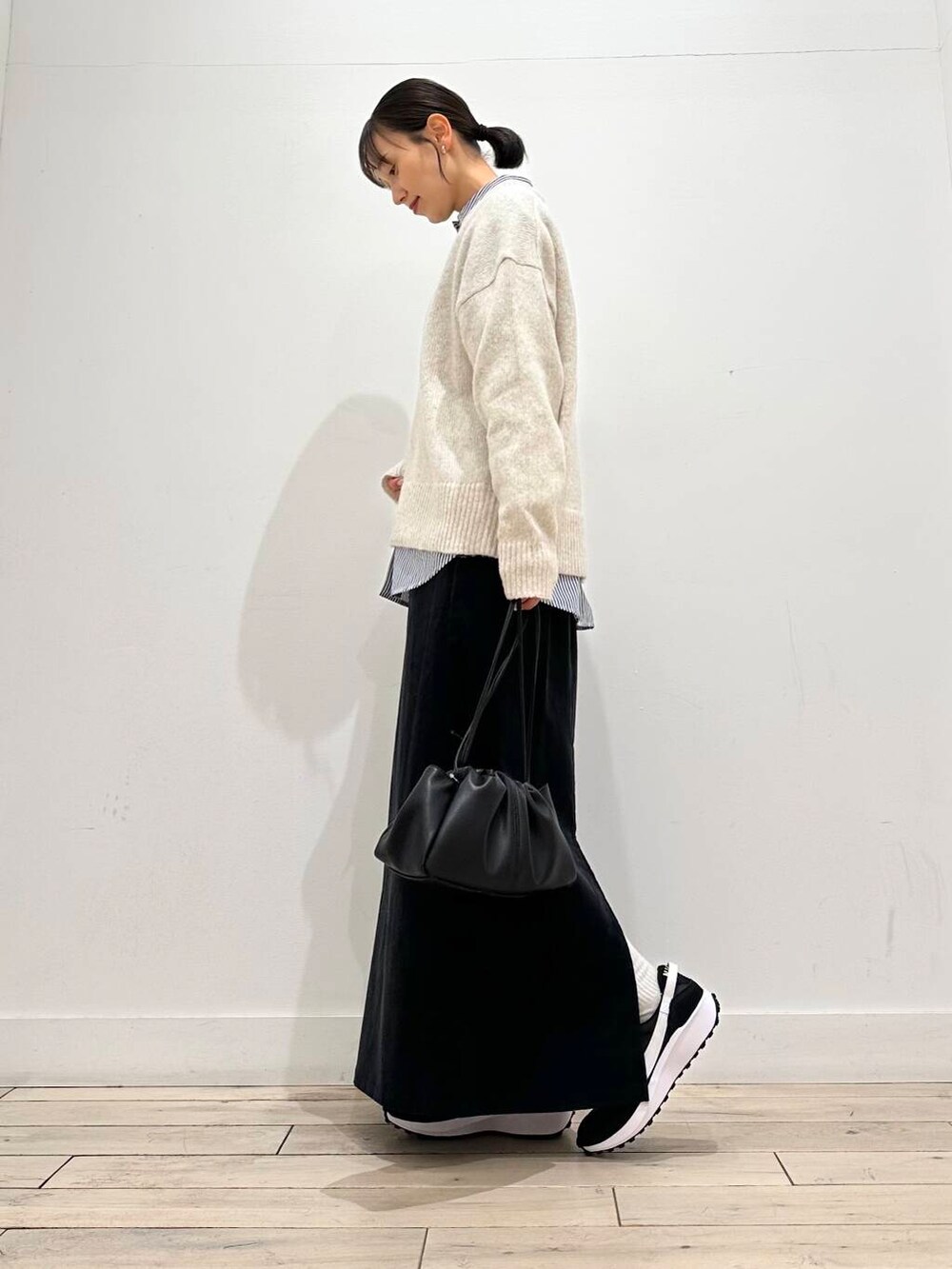 ブルー系のシャツ/ブラウス、グレー系のスカート、ホワイト系のニット/セーターを着用したレディースの冬コーディネートの3枚目の写真