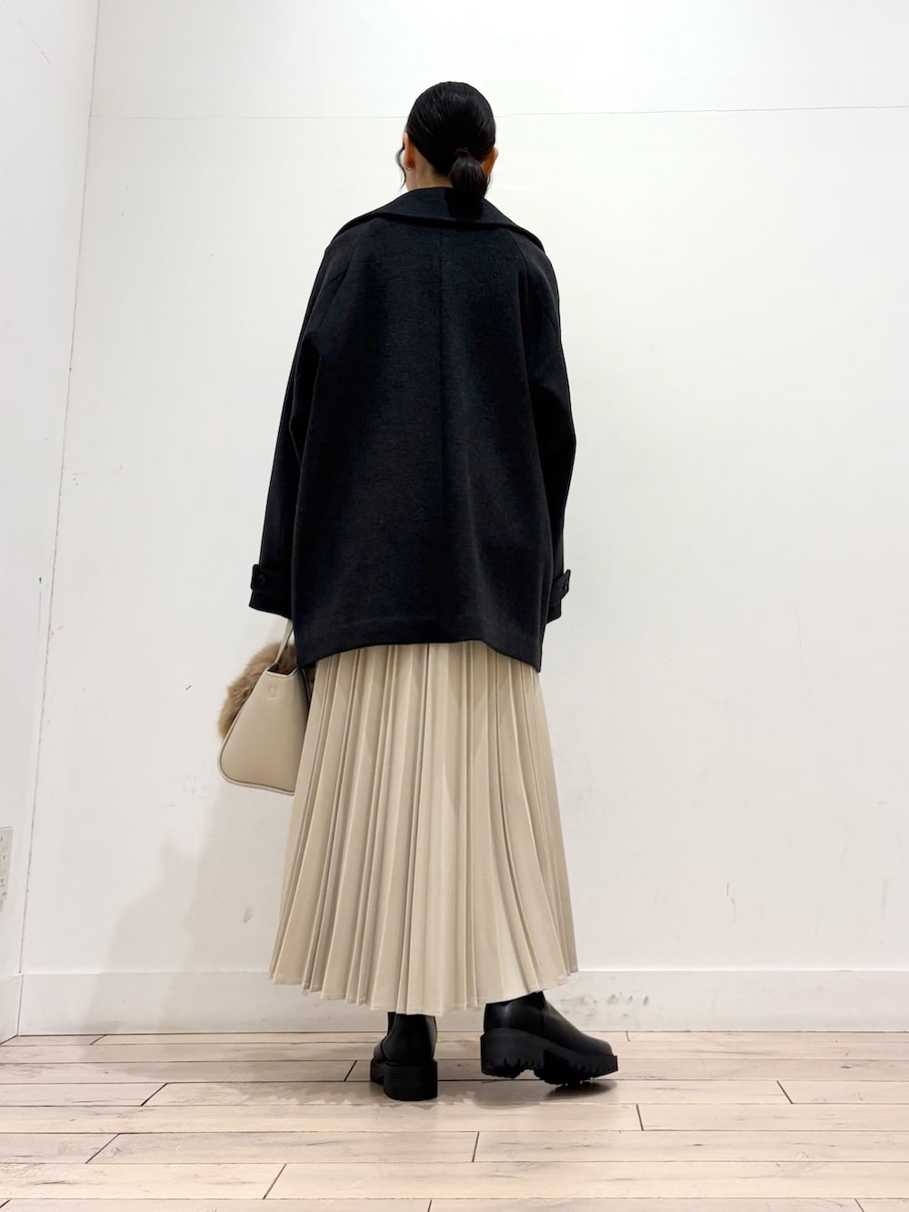 ホワイト系のTシャツ/カットソー、グレー系のピーコート、ブラック系のブーツを着用したレディースの冬コーディネートの4枚目の写真