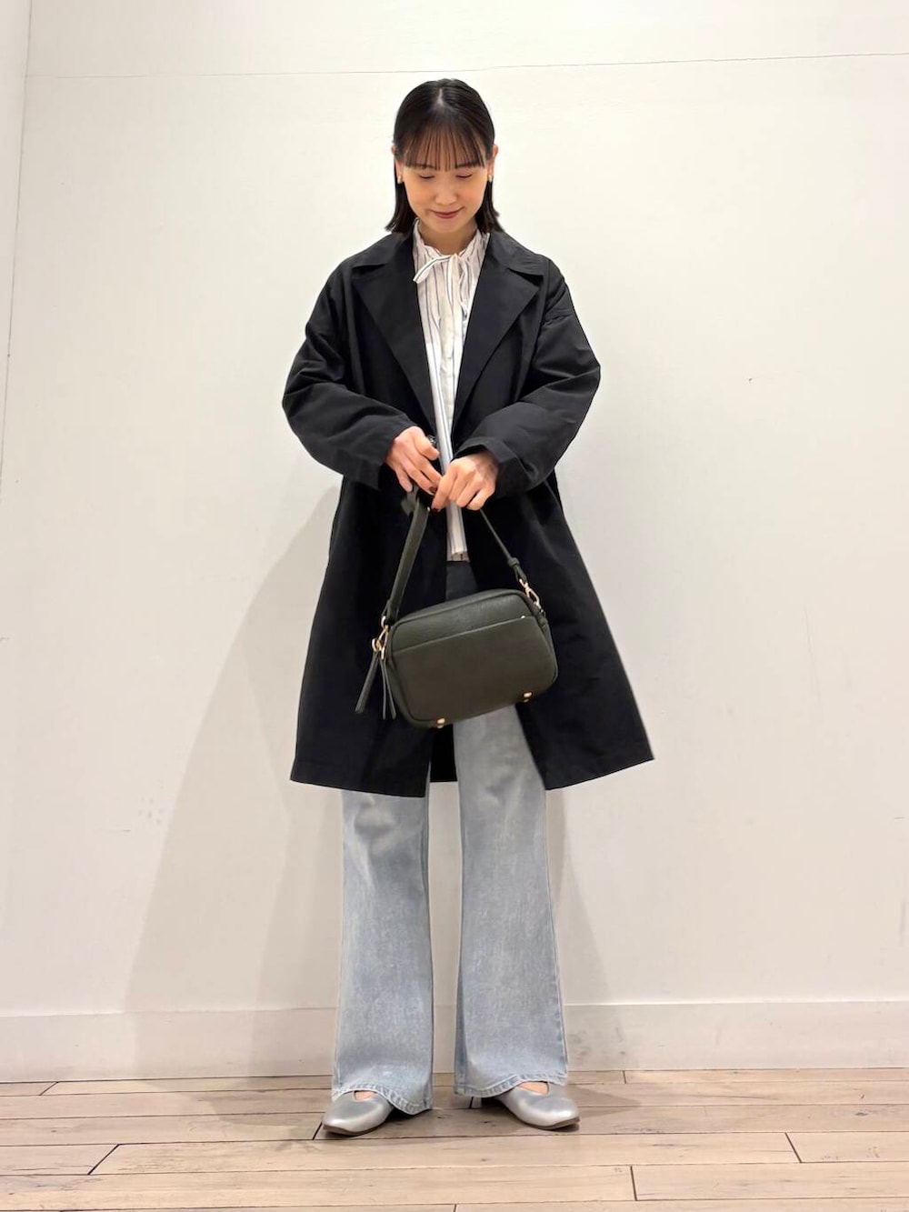 グリーン系のショルダーバッグ、シルバー系のパンプス、ブルー系のデニムパンツを着用したレディースの春コーディネートの5枚目の写真
