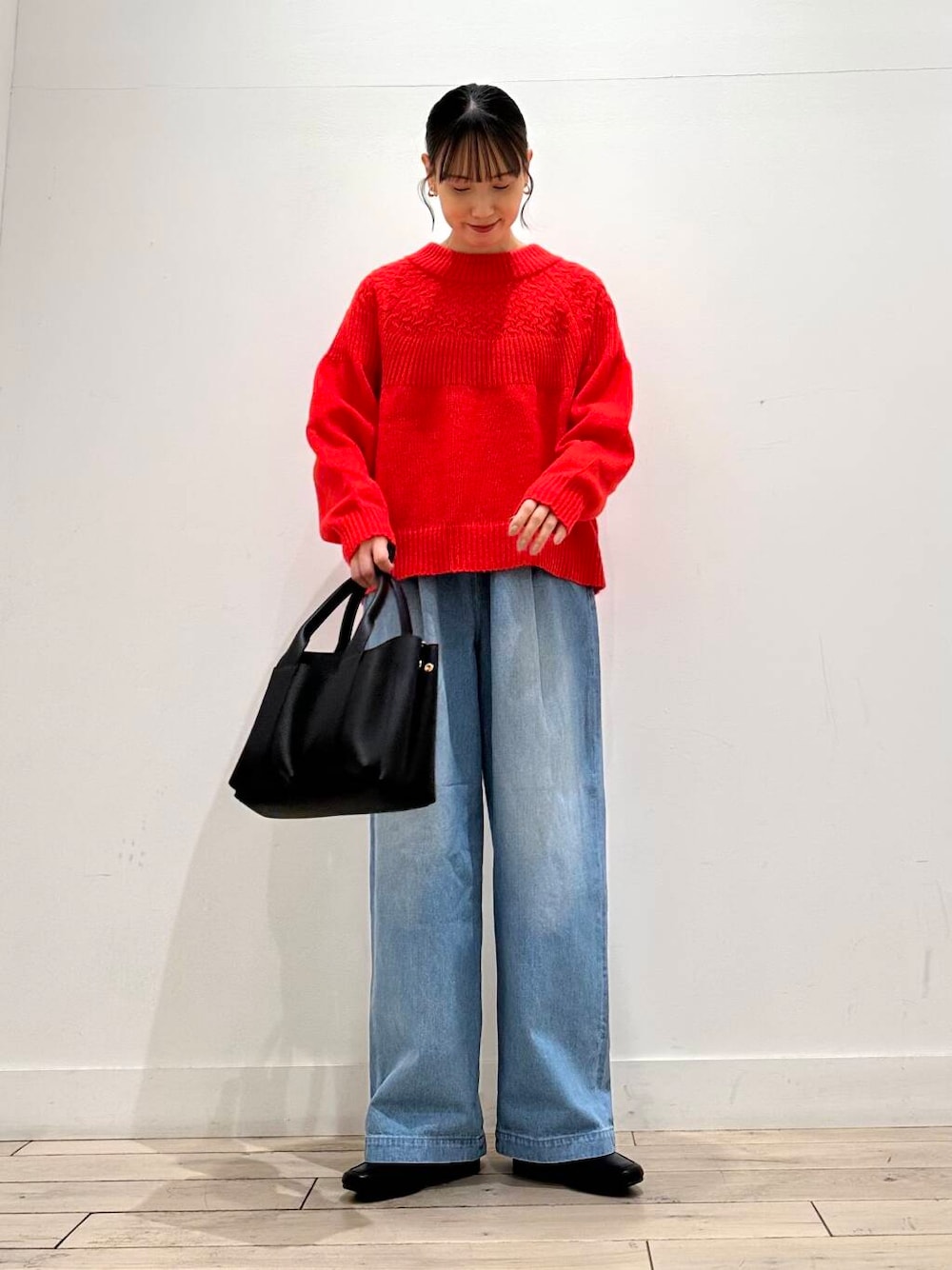 ブラック系のトートバッグ、グレー系のその他アウター、レッド系のニット/セーターを着用したレディースの冬コーディネートの2枚目の写真