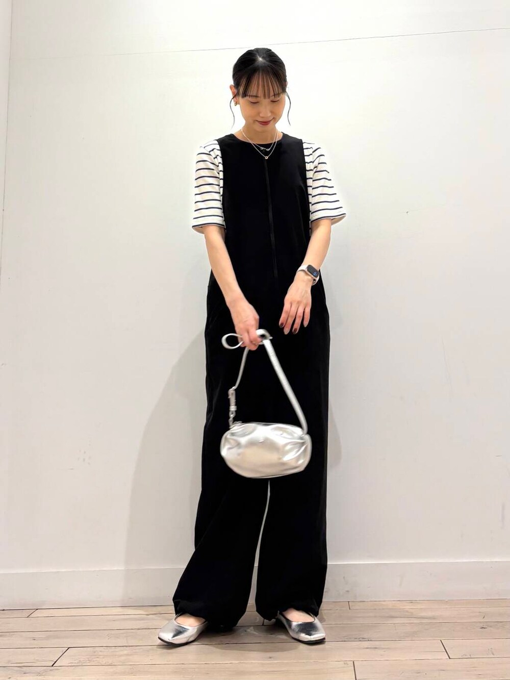 シルバー系のショルダーバッグ、ブラック系のワンピース、シルバー系のパンプスを着用したレディースの春コーディネートの4枚目の写真