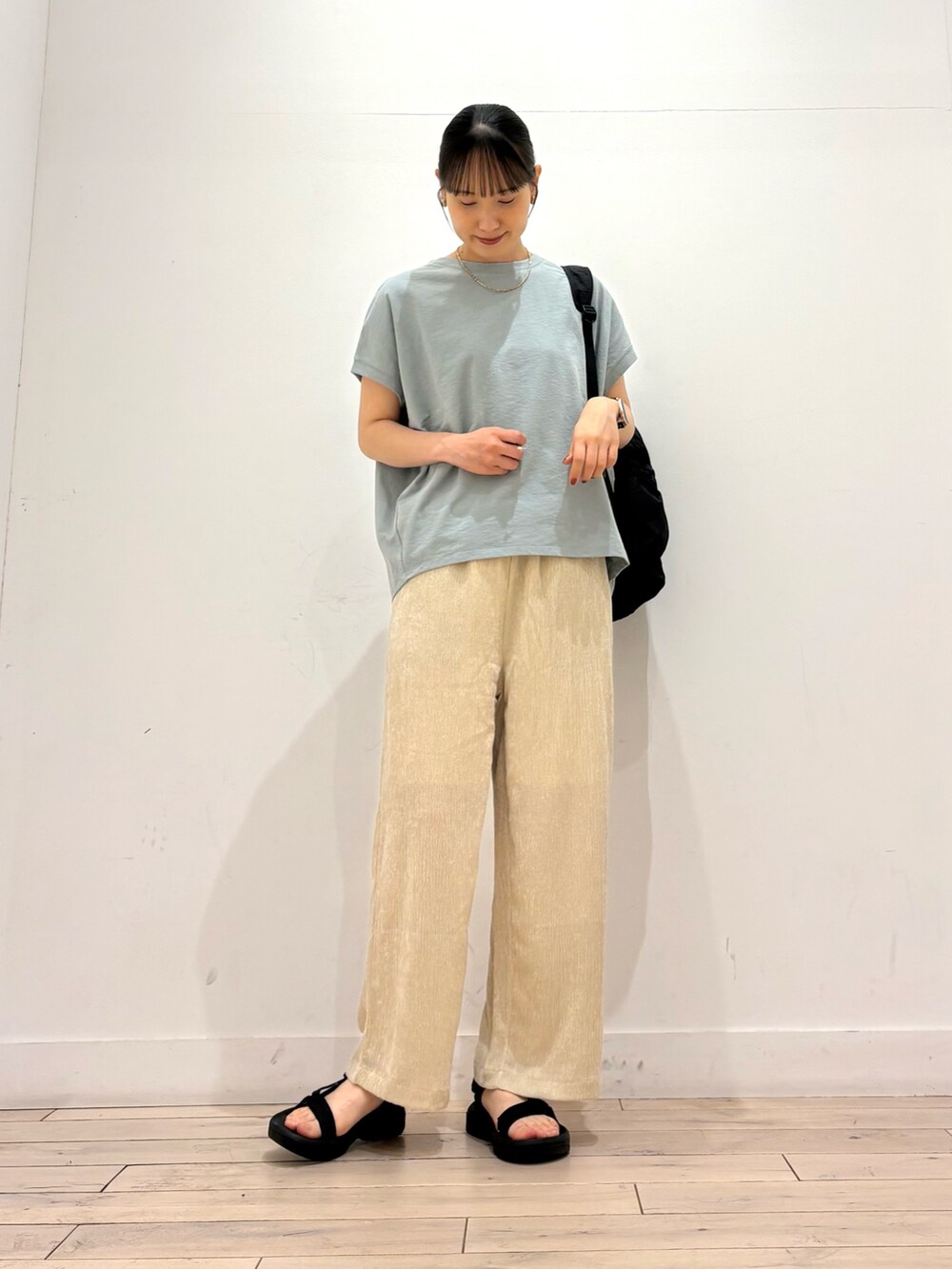 グリーン系のTシャツ/カットソー、ベージュ系のその他パンツ、ブラック系のバックパック/リュックを着用したレディースの夏コーディネートの2枚目の写真