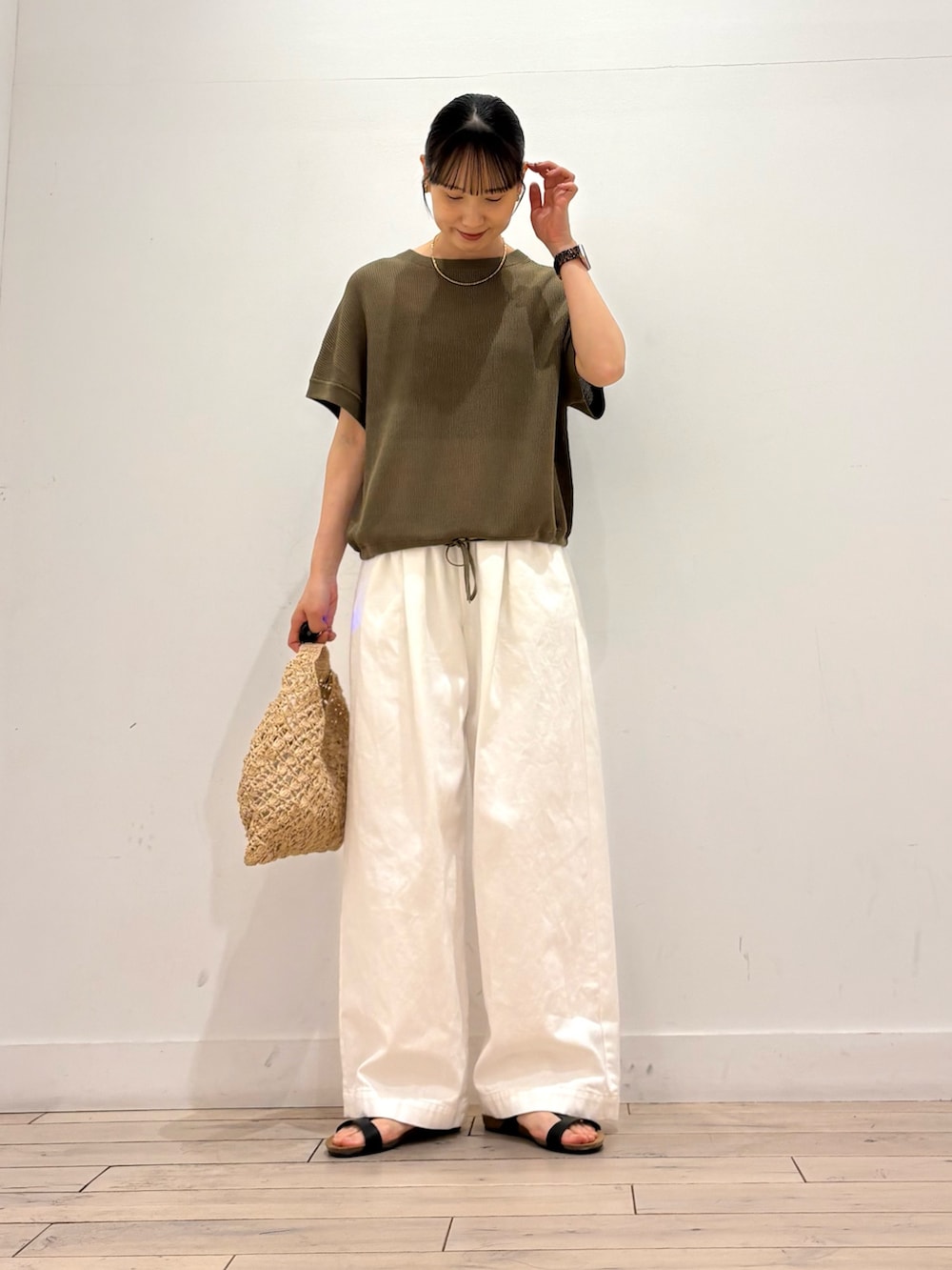 ホワイト系のその他パンツ、ベージュ系のハンドバッグ、ブラック系のサンダルを着用したレディースの夏コーディネートの2枚目の写真