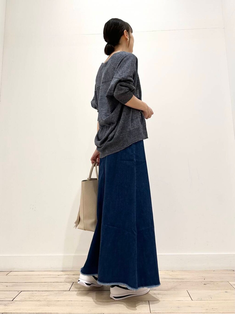 ホワイト系のトートバッグ、ホワイト系のタンクトップ、ブルー系のカーディガン/ボレロを着用したレディースの夏コーディネートの3枚目の写真