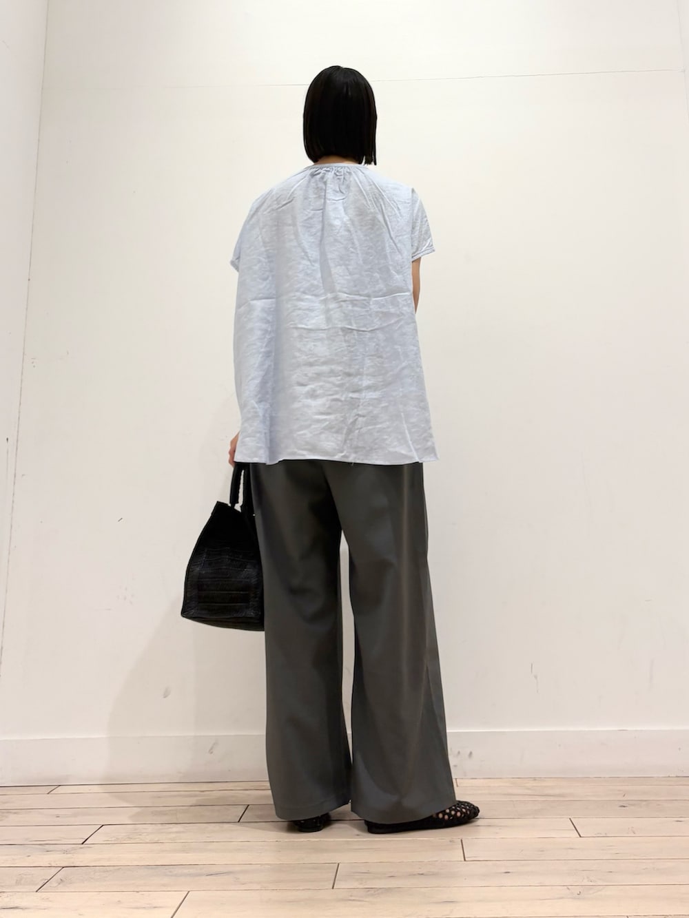 ブルー系のシャツ/ブラウス、グレー系のその他パンツ、ブラック系のハンドバッグを着用したレディースの春コーディネートの5枚目の写真