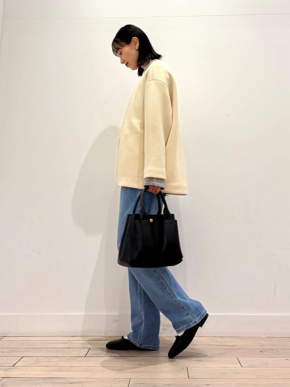 ブラック系のトートバッグ、グレー系のカーディガン/ボレロ、ホワイト系のノーカラージャケットを着用したレディースの冬コーディネートの2枚目の写真