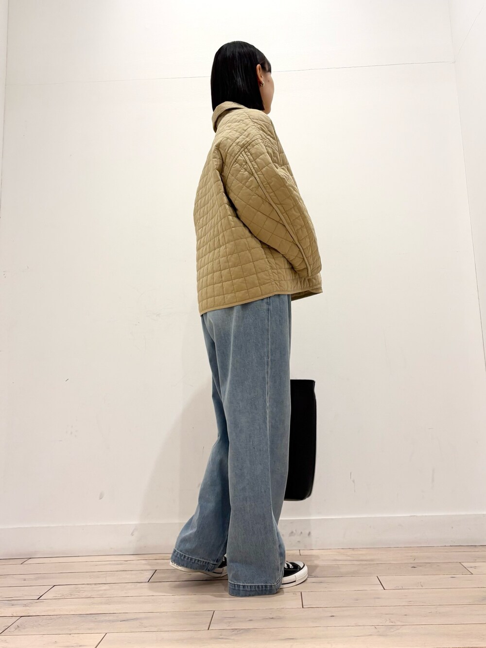 ホワイト系のTシャツ/カットソー、ベージュ系のダウンジャケット/コート、ブラック系のトートバッグを着用したレディースの冬コーディネートの4枚目の写真