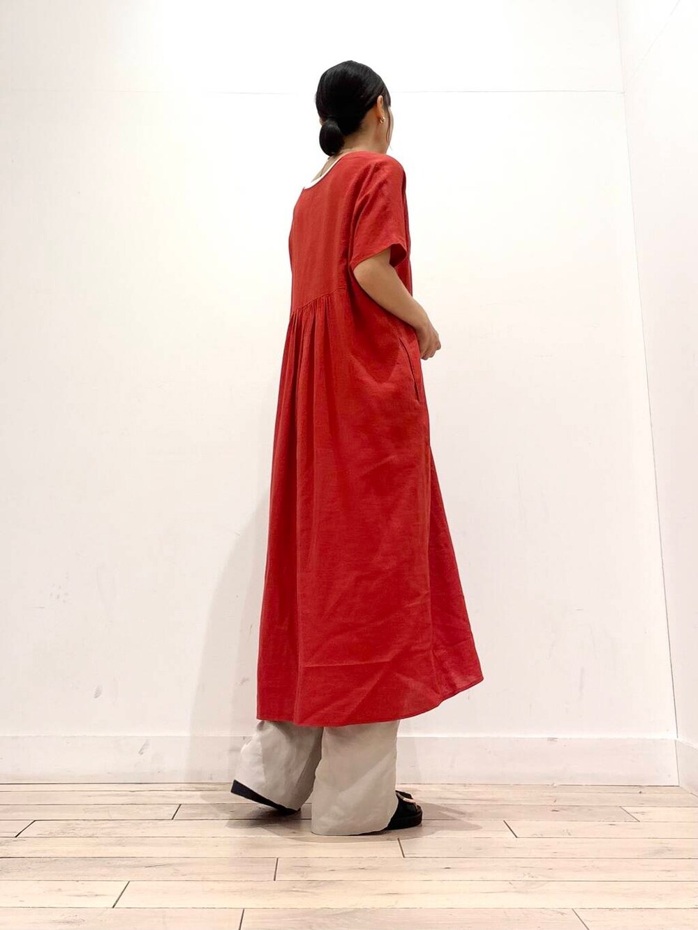 ブラック系のショルダーバッグ、ブラック系のサンダル、レッド系のワンピースを着用したレディースの夏コーディネートの4枚目の写真