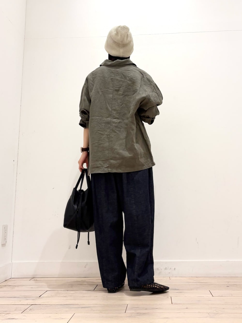 ブラック系のショルダーバッグ、ブラック系のサンダル、ブルー系のデニムパンツを着用したレディースの春コーディネートの4枚目の写真