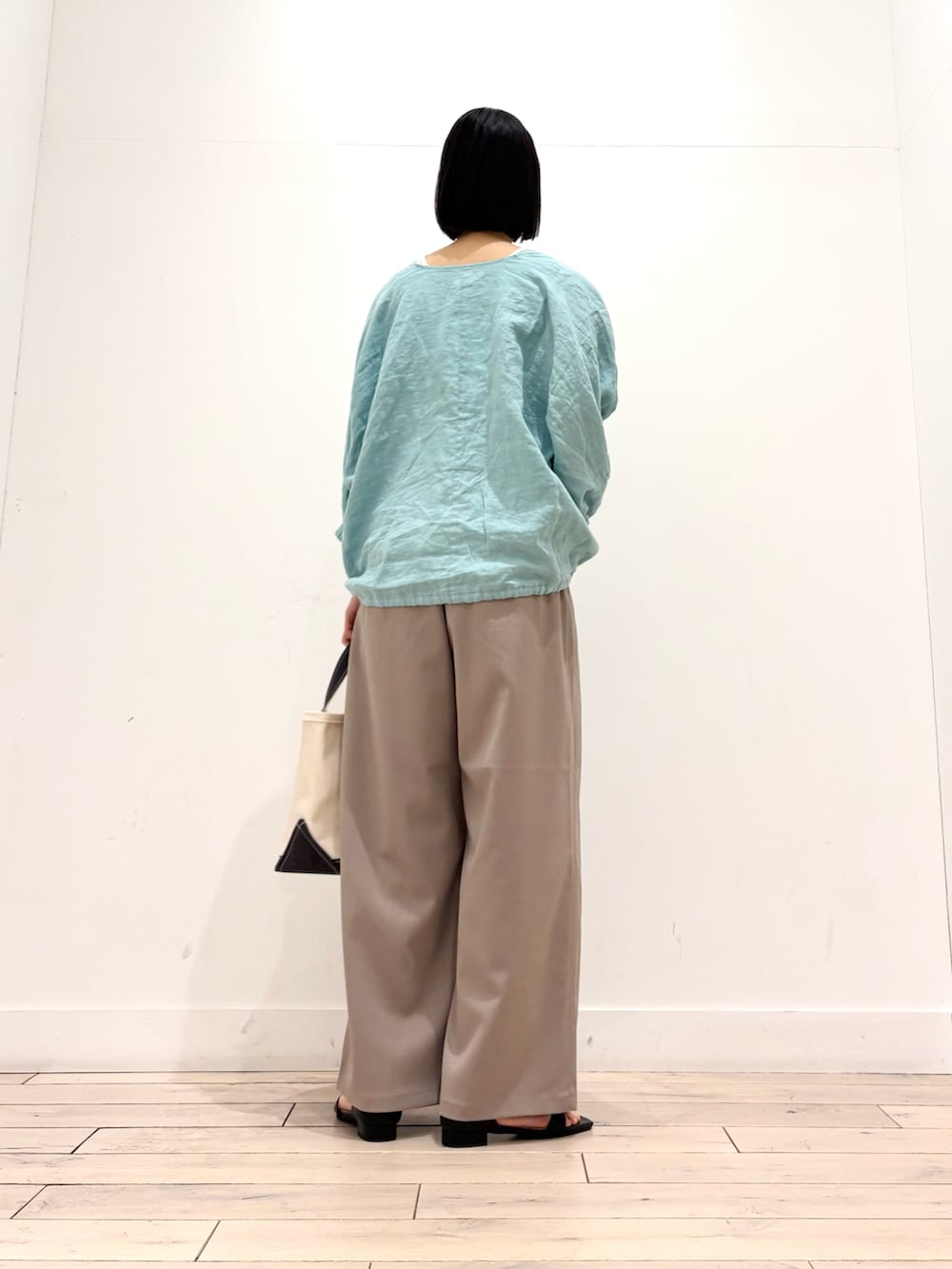 グリーン系のシャツ/ブラウス、ベージュ系のその他パンツ、グレー系のトートバッグを着用したレディースの春コーディネートの4枚目の写真
