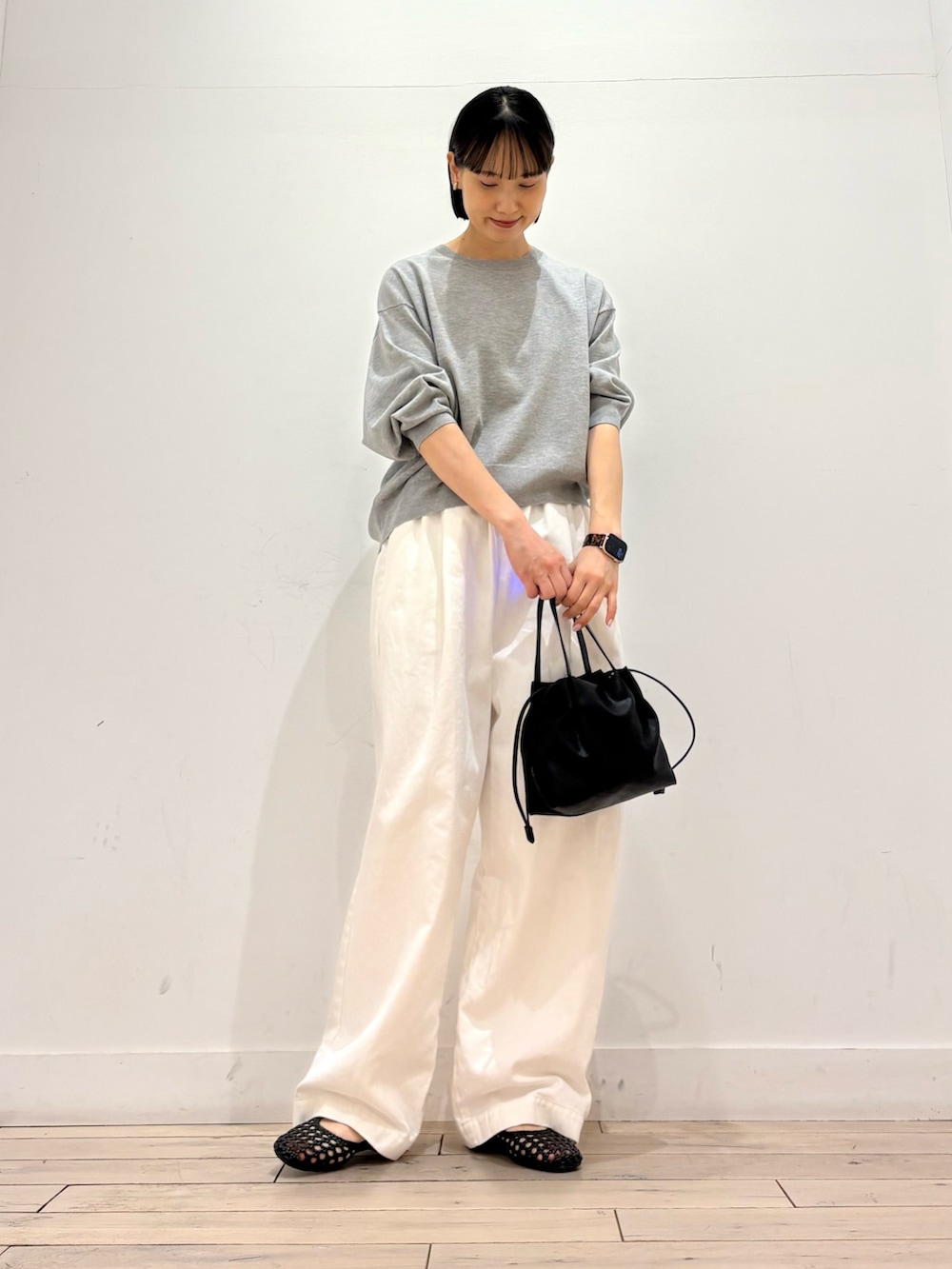 グレー系のTシャツ/カットソー、ブラック系のショルダーバッグ、ブラック系のサンダルを着用したレディースの春コーディネートの2枚目の写真