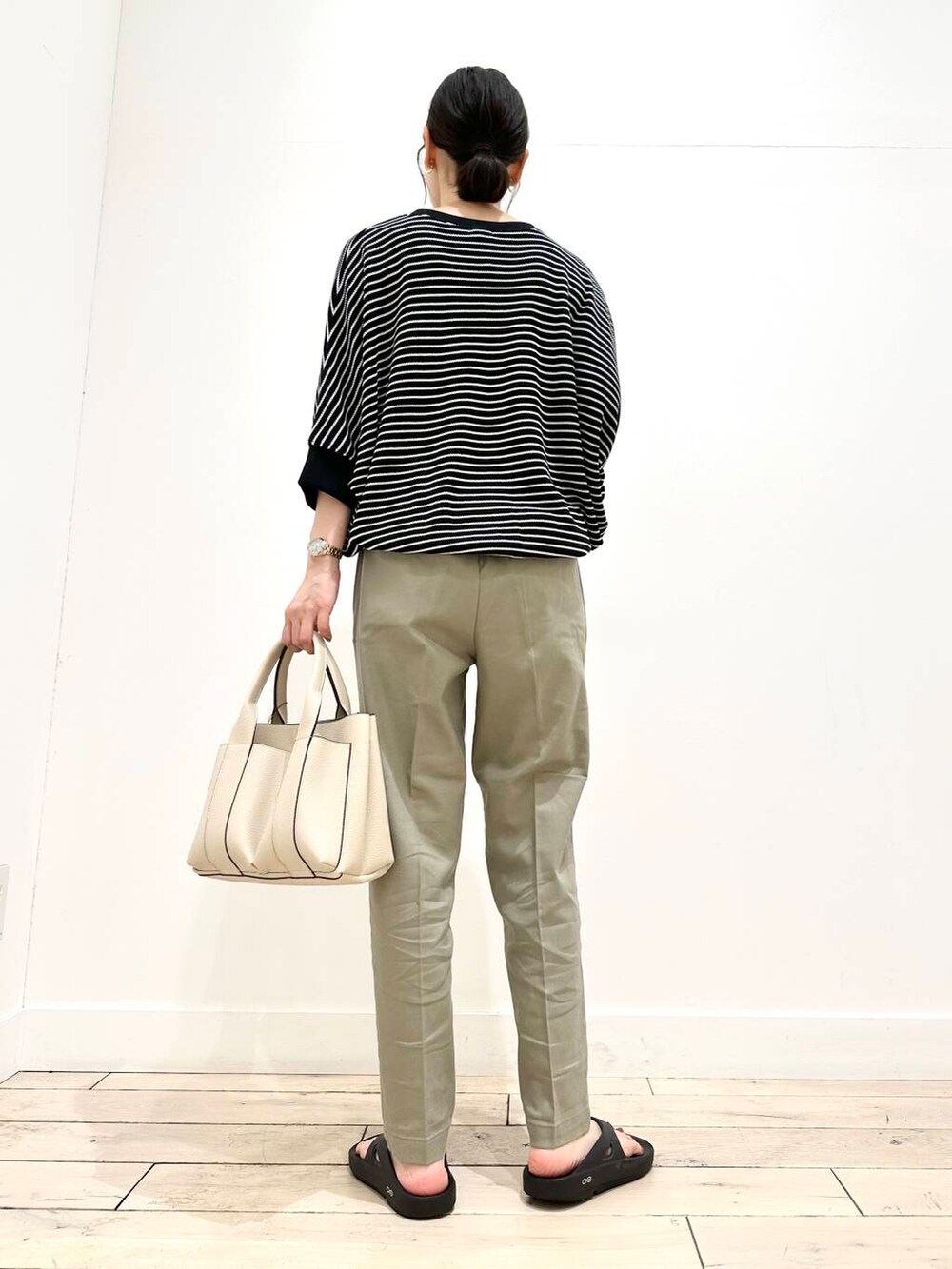 ホワイト系のトートバッグ、グリーン系のその他パンツ、ブラック系のTシャツ/カットソーを着用したレディースの夏コーディネートの3枚目の写真
