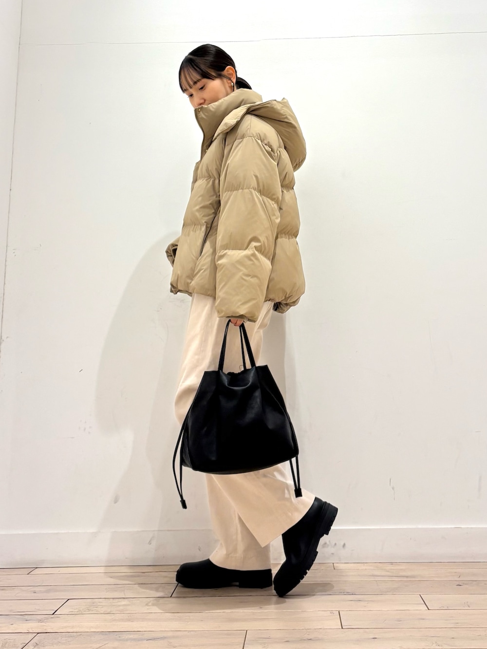 グレー系のニット/セーター、ベージュ系のダウンジャケット/コート、ホワイト系のその他パンツを着用したレディースの冬コーディネートの3枚目の写真