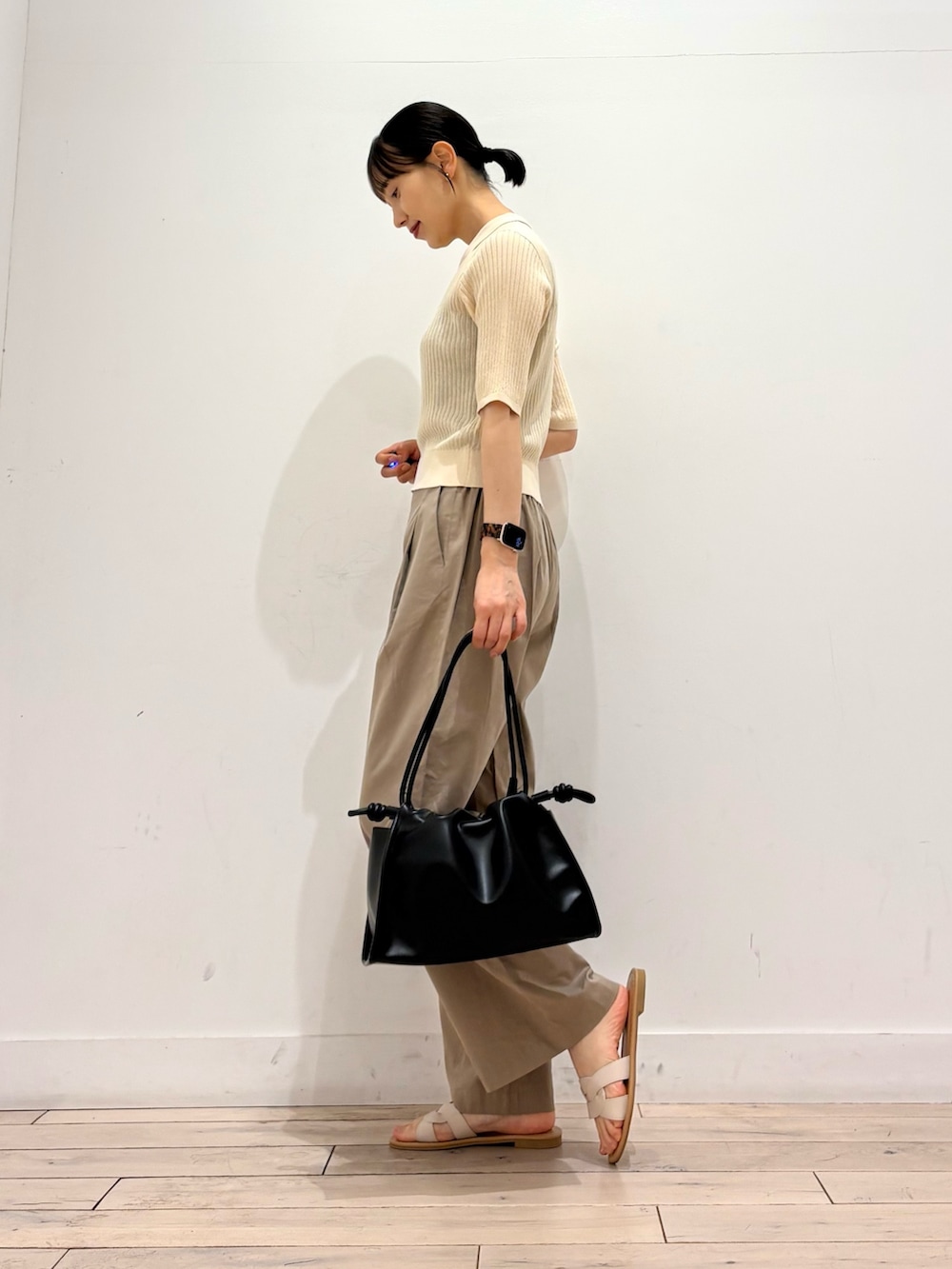 ホワイト系のニット/セーター、ベージュ系のその他パンツ、ブラック系のトートバッグを着用したレディースの夏コーディネートの3枚目の写真