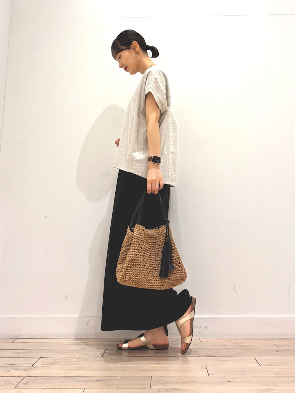 グレー系のTシャツ/カットソー、ブラック系のスカート、イエロー系のかごバッグを着用したレディースの夏コーディネートの3枚目の写真