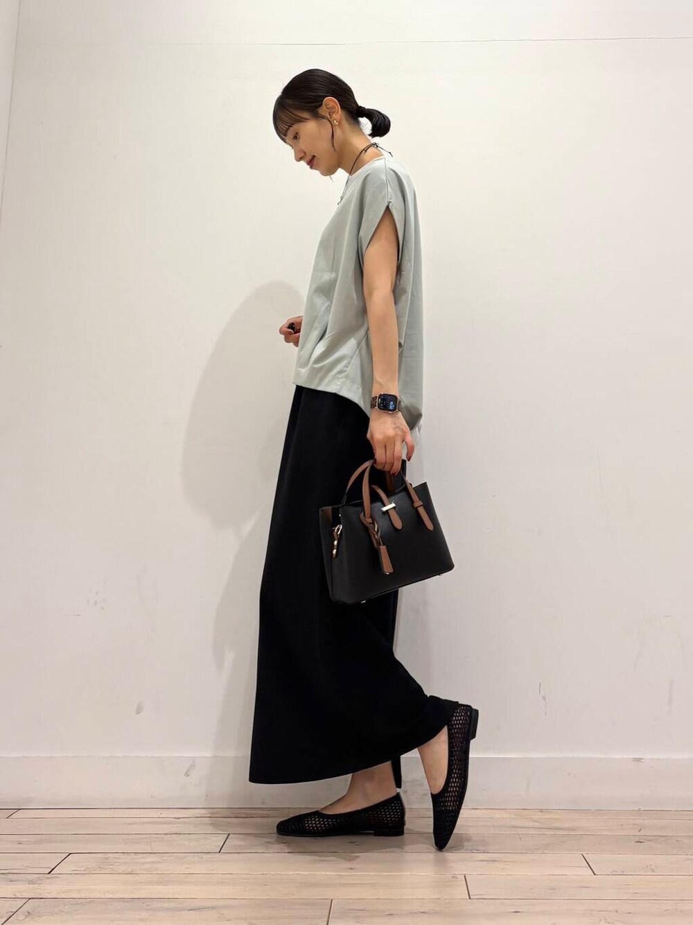 ブラック系のハンドバッグ、グリーン系のTシャツ/カットソー、ブラック系のバレエシューズを着用したレディースの夏コーディネートの3枚目の写真