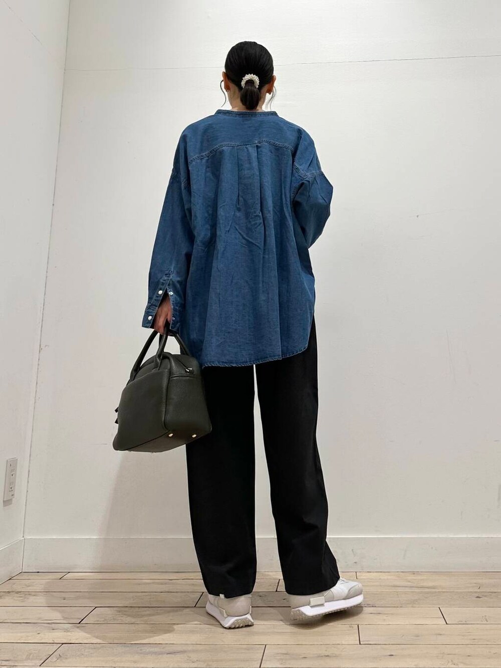 グリーン系のボストンバッグ、ブラック系のTシャツ/カットソー、ブルー系のシャツ/ブラウスを着用したレディースの冬コーディネートの3枚目の写真