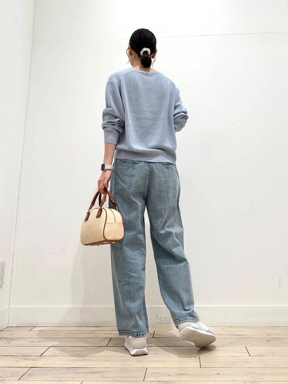 ブルー系のデニムパンツ、ベージュ系のその他アウター、イエロー系のボストンバッグを着用したレディースの冬コーディネートの7枚目の写真