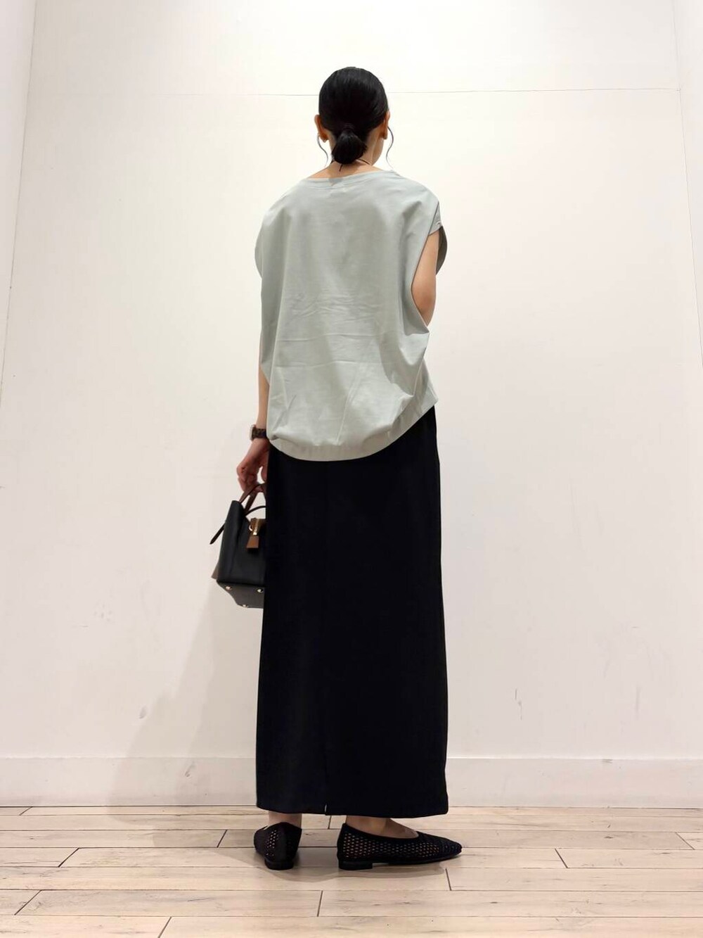 ブラック系のハンドバッグ、グリーン系のTシャツ/カットソー、ブラック系のバレエシューズを着用したレディースの夏コーディネートの4枚目の写真